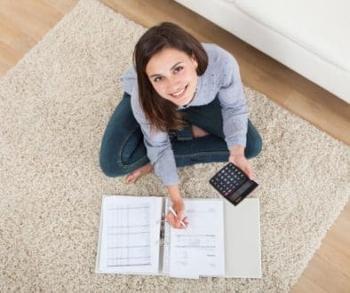 Woman Calculating Home Finances On Rug